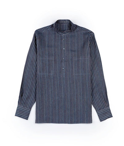 cette chemise est éditée dans une toile pur lin rayée. Elle doit son effet de faux-uni gris bleuté à la méthode de teinture "en pièce" employée. Il s’agit d’une technique prévoyant qu’un vêtement, en général en tissu brut non-coloré, soit teint à la toute fin du processus de confection, puis lavé. Cela permet d’accentuer les caractéristiques matérielles du tissu et d'obtenir cet effet irrégulier et un peu "blanchi".
