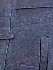 Le pantalon Jules montré ici est coupé dans un denim extensible bleu indigo. Ce denim ajoute au coton une touche d’élasthanne pour augmenter le confort au porter. Sa trame est noire, ce qui renforce la profondeur de son indigo.